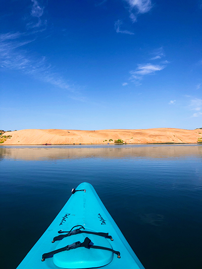 Blue kayak heading to the sand dunes in Morro Bay